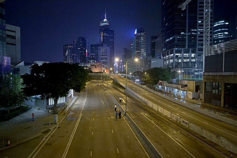 Workers check the main road after police removed and cleared the occupied area outside government headquarters in Hong Kong Thursday, Dec. 11, 2014. Hong Kong police on Thursday took away demonstrators who refused to leave the main pro-democracy protest camp and tore down their tents in a final push to retake streets occupied by activists for two and a half months. (AP Photo/Kin Cheung)