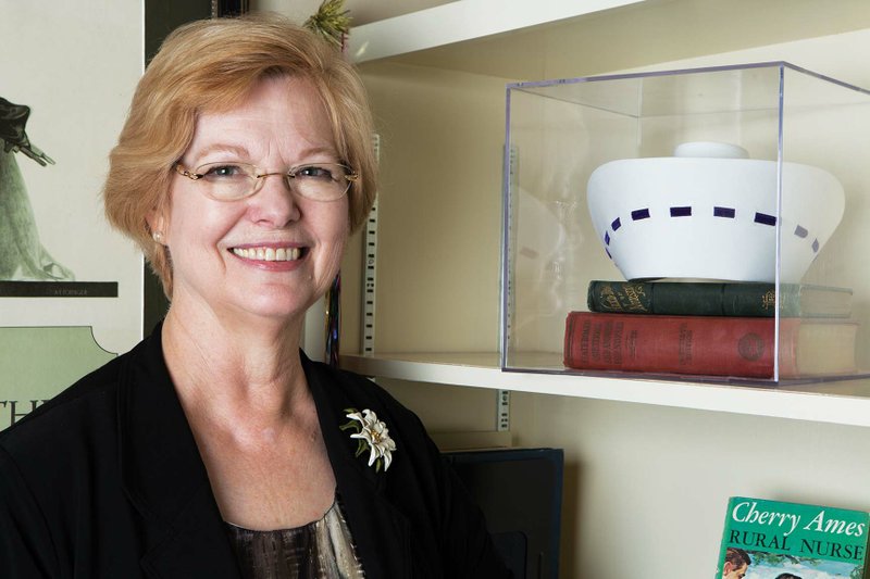Barbara Williams, chairwoman of the University of Central Arkansas Department of Nursing, stands next to bookshelves in her office where she has nursing memorabilia displayed, including the nurse’s cap that she wore in the 1960s and ’70s. In January, she will become chairwoman of the Conway Regional Health System Board of Directors, on which she has served since 2010. She said that despite significant changes in health care, nurses will always play a vital role in that care.