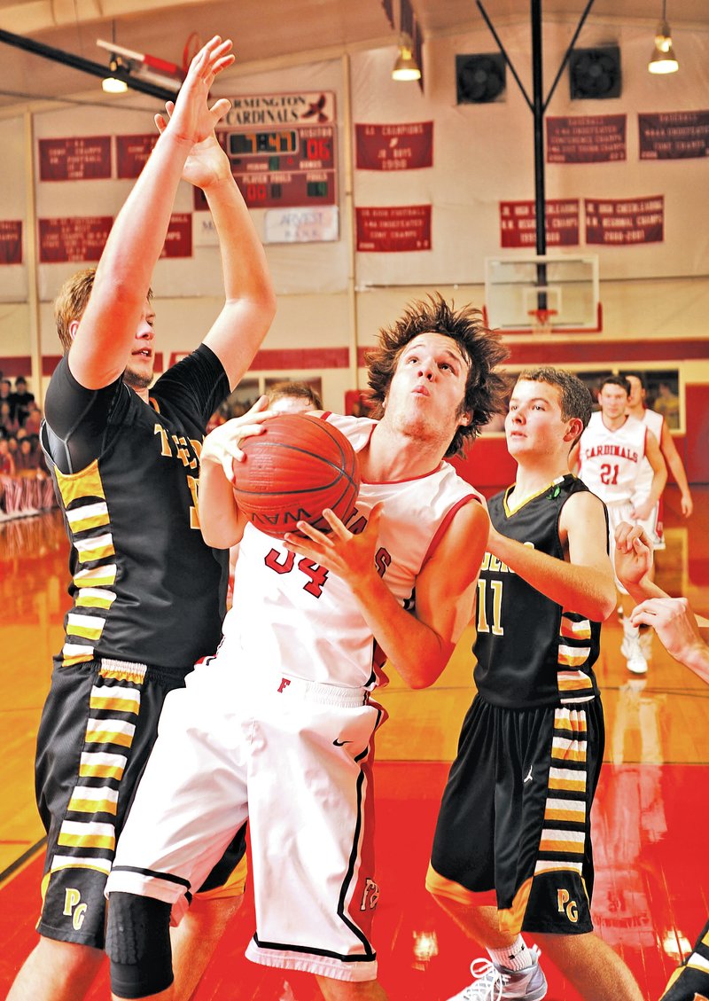  STAFF PHOTO ANDY SHUPE Flint Oxford, center, of Farmington pulls down a rebound as Dylan Soehner, left, and Parker Galligan, right, of Prairie Grove apply pressure during the first half Friday in Farmington.