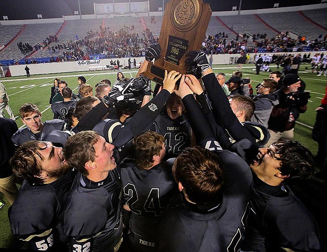 Charleston players celebrate after battling back to beat Smackover 33-26 to win the Class 3A state championship Friday at War Memorial Stadium in Little Rock. The victory gave the Tigers their second consecutive title and extended their winning streak to 29 games.