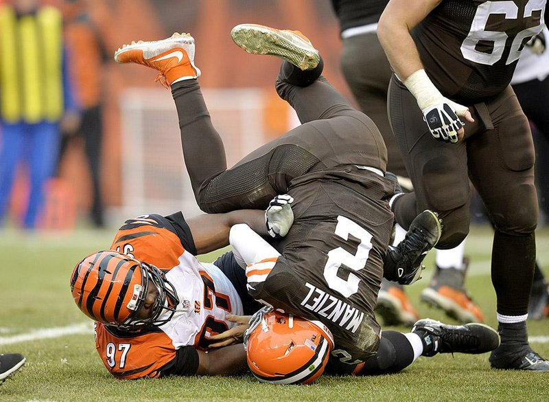 Cincinnati Bengals defensive tackle Geno Atkins (97) sacks Cleveland Browns quarterback Johnny Manziel (2) in the third quarter of an NFL football game Sunday, Dec. 14, 2014, in Cleveland. (AP Photo/David Richard)