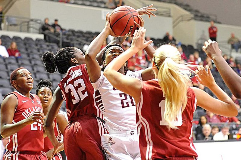 Photo courtesy of UALR
UALR forward Shanity James (20) looks for a shot between Oklahoma defenders
LeNesia Williams (32) and Peyton Little in the Trojans? 66-62 victory Sunday
at the Jack Stephens Center in Little Rock.