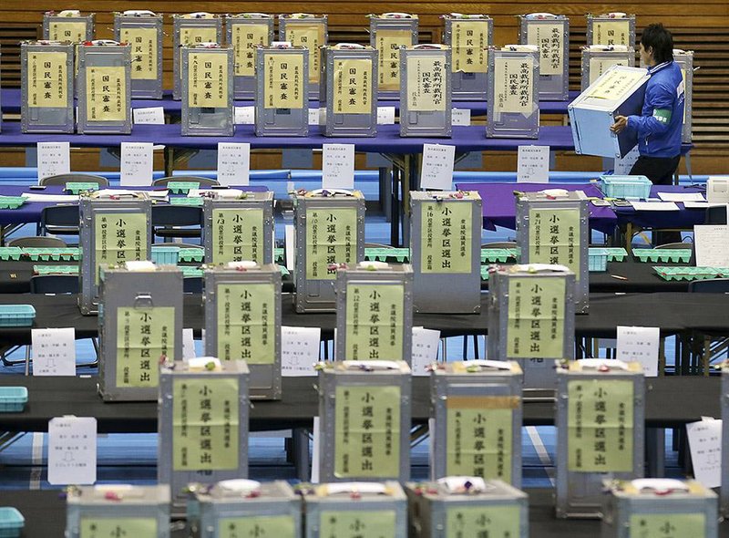 Election staff members carries a  ballot box for vote counting in the parliamentary lower house elections at a ballot counting center in Tokyo, Sunday, Dec. 14, 2014. (AP Photo/Koji Sasahara)