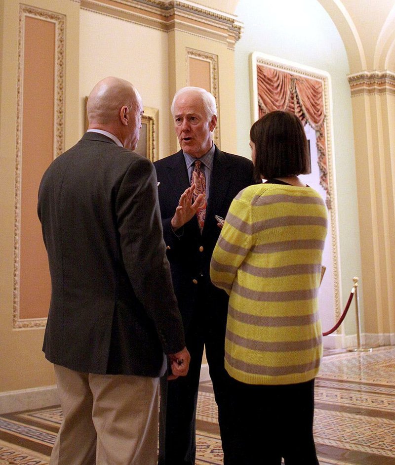 Senate Minority Whip John Cornyn of Texas (center) talks to reporters Saturday on Capitol Hill while the Senate worked on presidential nominations and a stopgap spending bill. 