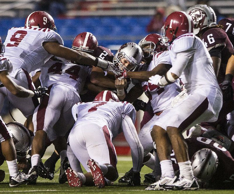 Arkansas Democrat-Gazette/MELISSA SUE GERRITS - 12/05/2014 - Benton's Thomas Harris is grabbed by a pile of Pine Bluff defense during their championship game December 5, 2014 at War Memorial Stadium in Little Rock. 