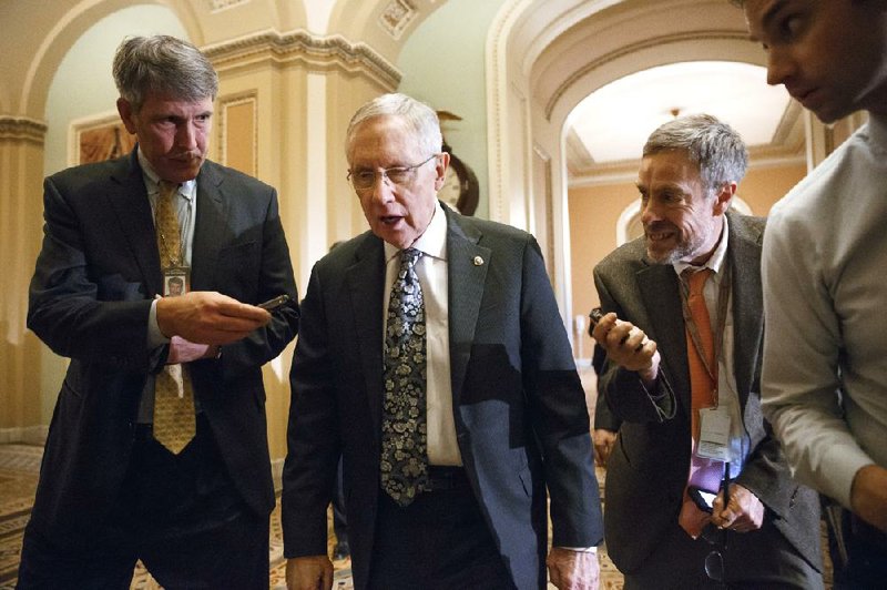 Senate Majority Leader Harry Reid, D-Nev., walks to the Senate chambers Tuesday for a final evening of action that included confirmation of 12 judicial appointees and temporary approval of tax breaks. 