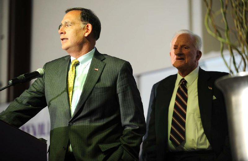 In this file photo, U.S. Sen. John Boozman, left, introduces Frank Broyles, former University of Arkansas football coach and athletics director, Tuesday, Nov. 26, 2013, during the Fayetteville Chamber of Commerce's annual meeting at the Bulldog Activities and Recreation Center on the Fayetteville High School campus.