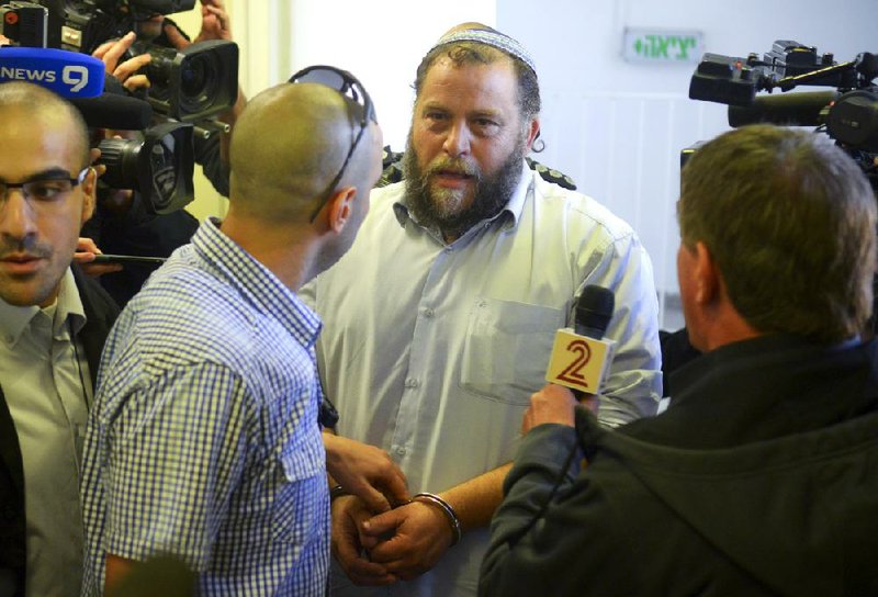 Bentzi Gopstein, leader of the extreme rightist movement Lehava, is handcuffed as he arrives for his hearing at a Jerusalem court Tuesday. 