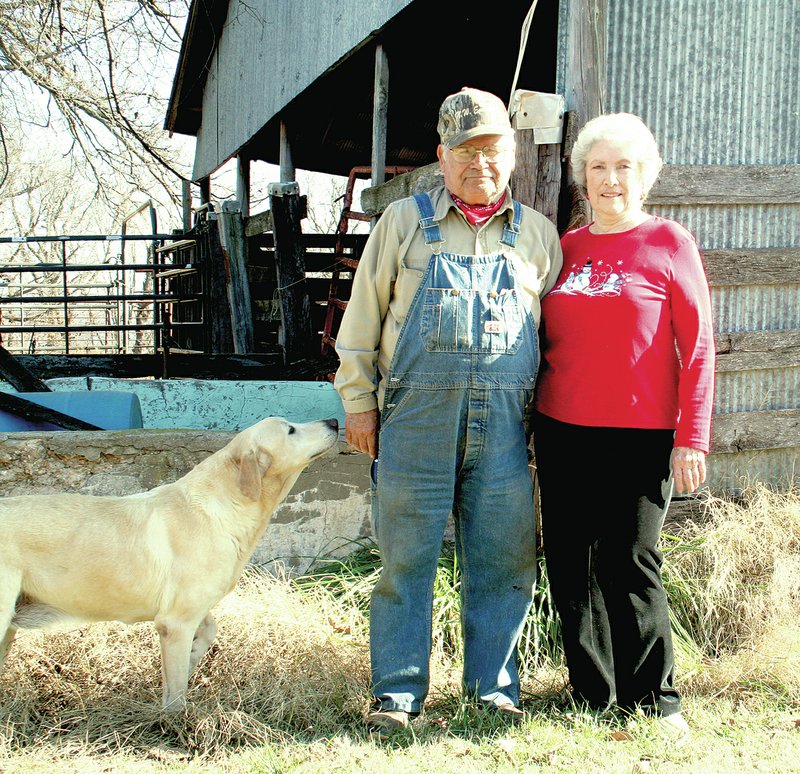 PAT HARRIS ENTERPRISE-LEADER Roger and Mary Alice Pitts pose in front of an old barn with their dog Yeller on the Pitts family Sugar Hill Ranch. The farm was named one of Arkansas Agriculture Department&#8217;s Century farms. The property has been in the family since 1914.