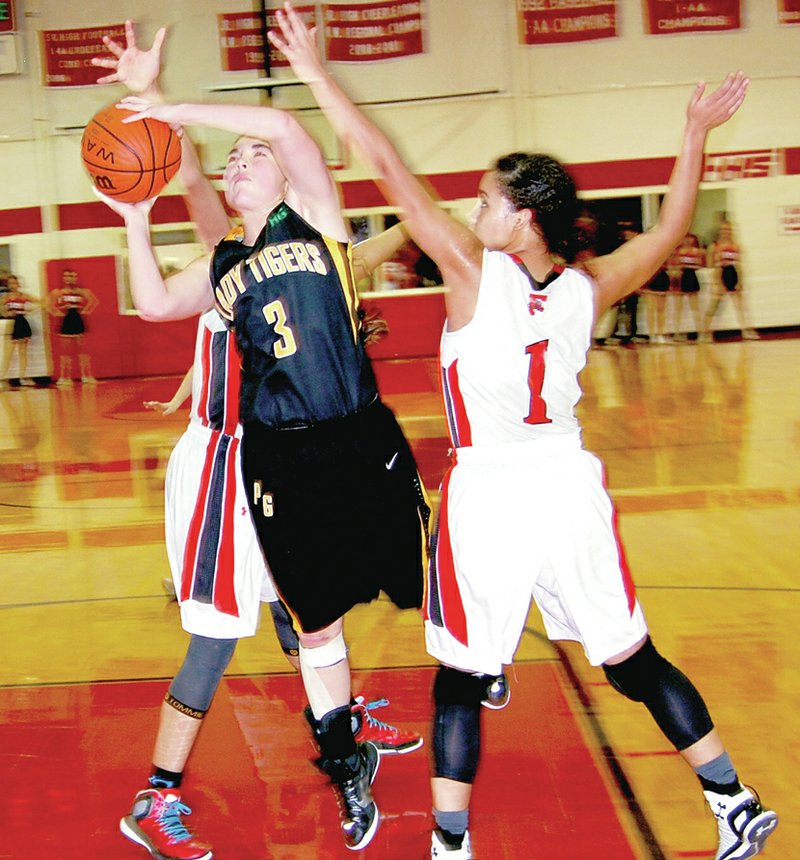 BEN MADRID ENTERPRISE-LEADER Prairie Grove sophomore Parker Lopez tries to score between two Farmington defenders including Tayton Hopkins (right). The Lady Cardinals beat Prairie grove 53-42 on Friday in the final game of the U.S. 62 girls basketball rivalry to be played at Mryl Massie Gymnasium.