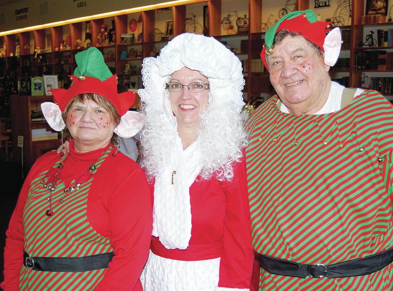 Santa&#8217;s elves and Mrs. Santa (Jackie Whitehead, Darla Threet and Denver Whitehead) were on hand at the Gentry Public Library open house on Saturday afternoon, greeting visitors and giving away library memberships. They also rode on the library&#8217;s float in the evening Christmas parade.