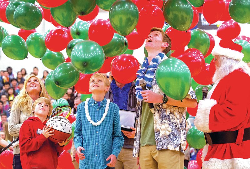 STAFF PHOTO JASON IVESTER Gunnison Riggins, 10, center, watches balloons drop Tuesday with friends and family during a ceremony at the Rogers High School gym. With support from the school&#8217;s Distributive Education Clubs of America program, Gunnison&#8217;s family was given a trip to Hawaii with the Make-A-Wish Foundation. Gunnison has been diagnosed with neuroblastoma.