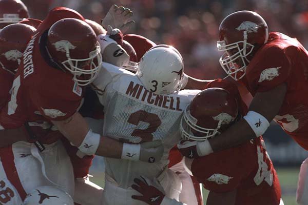 Texas running back Hodges Mitchell is tackled by a gang of Razorbacks during the first quarter of the Cotton Bowl in Dallas on Saturday, Jan. 1, 2000. 
