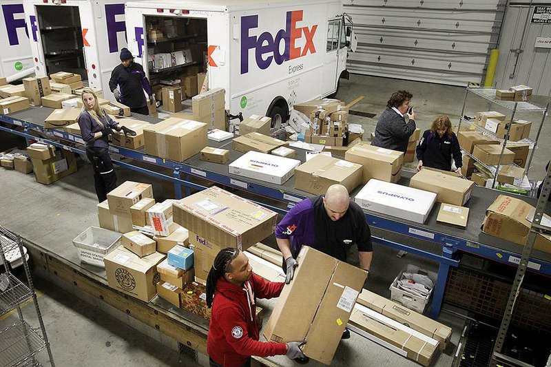 FedEx employees sort packages Monday at a shipping facility in New York City. The company has had several days this month that rank among the busiest in its history, executives say. 