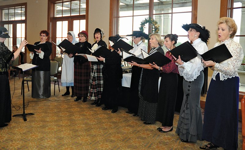 The Sentinel-Record/Mara Kuhn HISTORY LESSON: Lynn Payette, left, directs Cantate, the women's vocal ensemble dressed in period costumes and sponsored by the Hot Springs Alumnae Chapter of Sigma Alpha Iota at its annual holiday luncheon.