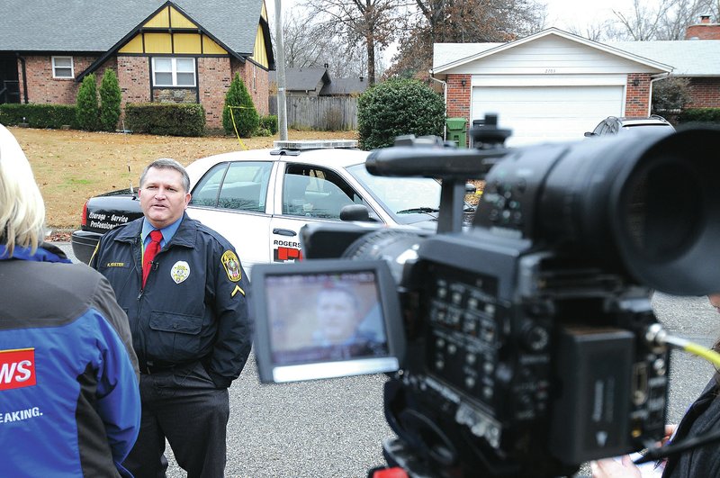 Staff Photo J.T. Wampler Keith Foster, Rogers police public information officer, speaks Thursday with a reporter about a child abduction in Rogers.