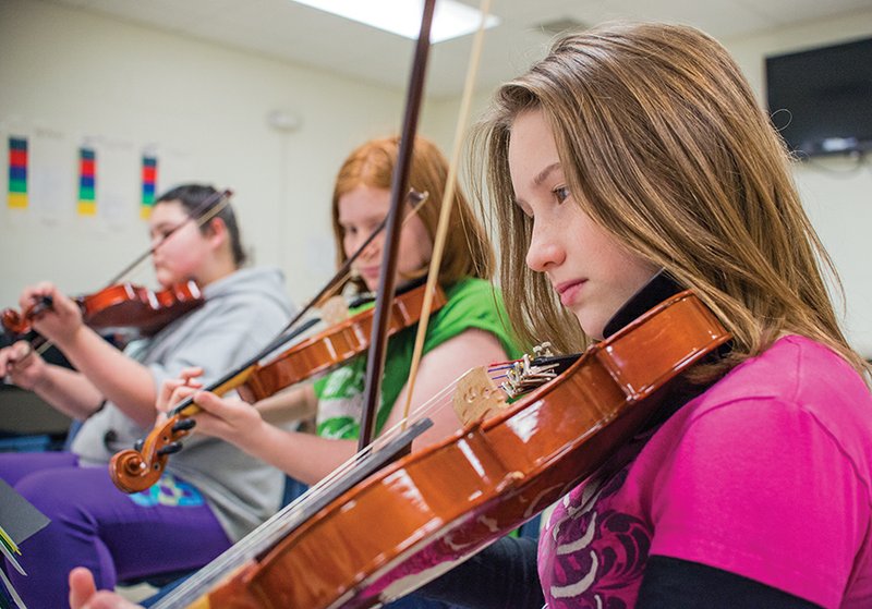 Jordan Sisk, from left, Jenifer Holt and Charly Woods play the fiddle in their music class at Mountain View Middle School.
