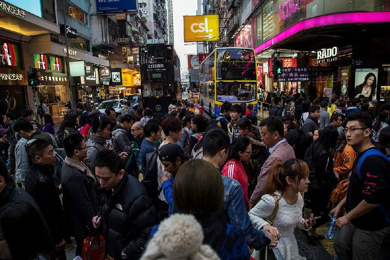 Pedestrians cross a road in the Causeway Bay district of Hong Kong. Economic woes in Hong Kong have curtailed retail sales.