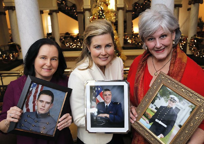 Dr. Kim Hurlbut (from left), Rachel O. Smith and Teri Bunce show off photos of their sons, Josh, Michael and Patrick, all cadets and midshipmen at the nation’s military academies. The mothers are members of parents’ associations designed to, as Smith says, “support the cadets, number one, and the parents, number two.” The forthcoming All Academies Holiday Celebration will honor the cadets’ and midshipmen’s dedication and commitment. 