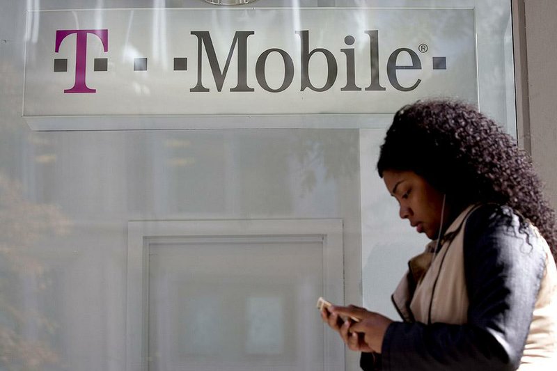 A pedestrian passes a T-Mobile Inc. retail store in Washington, D.C., in October. The mobile-phone company began a refund program in July for overbilling customers for unauthorized charges. 