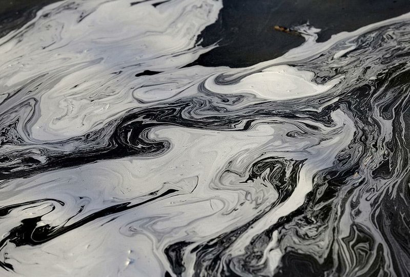 Coal ash swirls on the surface of the Dan River in Virginia after a coal-ash pond sprang a leak in February. Duke Energy said it spent $20 million to clean up the mess. 
