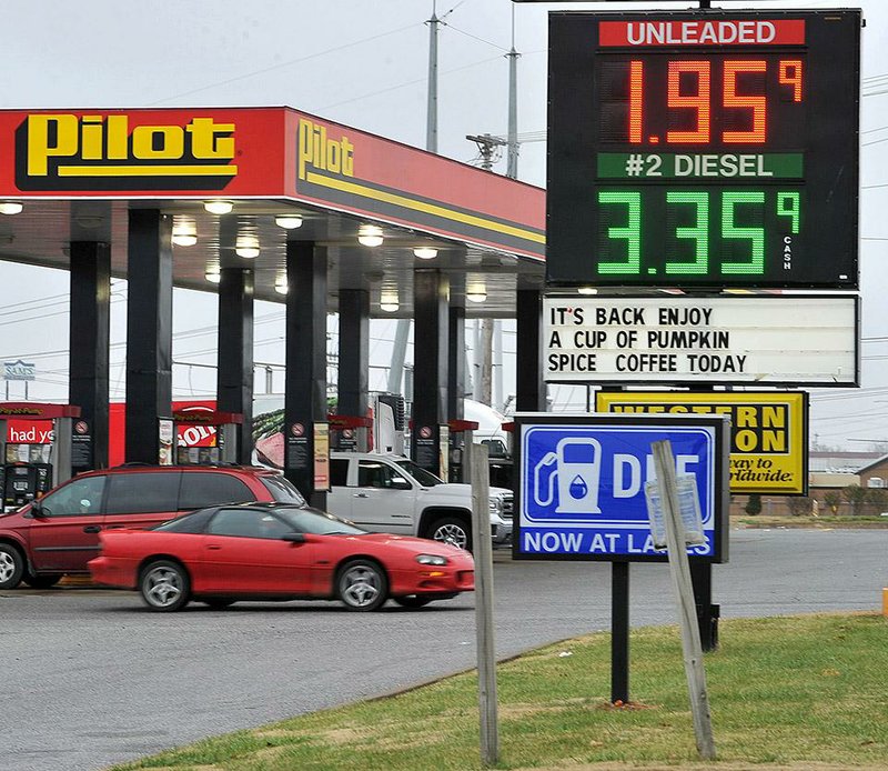 Motorists fill up Friday at the Pilot station on U.S. 412 in Springdale, where unleaded gasoline was priced below $2 a gallon. The average price of a gallon of gasoline Friday in Arkansas was $2.31. 