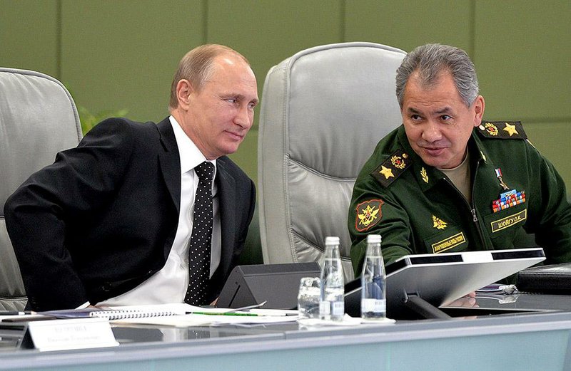Russian President Vladimir Putin (left) confers with Defense Minister Sergei Shoigu during a meeting with senior military officials Friday in Moscow. Putin, touting Russia’s nuclear forces as a “major factor in maintaining global balance,” vowed to continue an ambitious military buildup. 