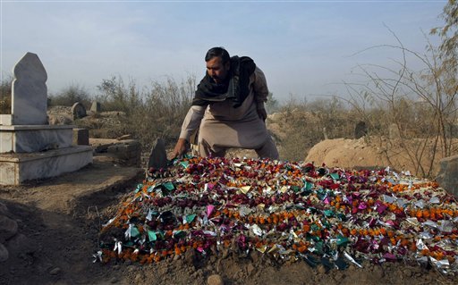 Pakistani gravedigger Taj Muhammad adjusts wreaths on a grave during his routine visit at the Rahman Baba graveyard in Peshawar, Pakistan, Saturday, Dec. 20, 2014. Muhammad, one of the gravediggers at Peshawar’s largest graveyard has a rule. He said he never cries when he buries the dead. He's a professional, he said. But as the dead bodies, mostly children, started coming in from a school massacre this week that killed 148 people, he began to weep. 