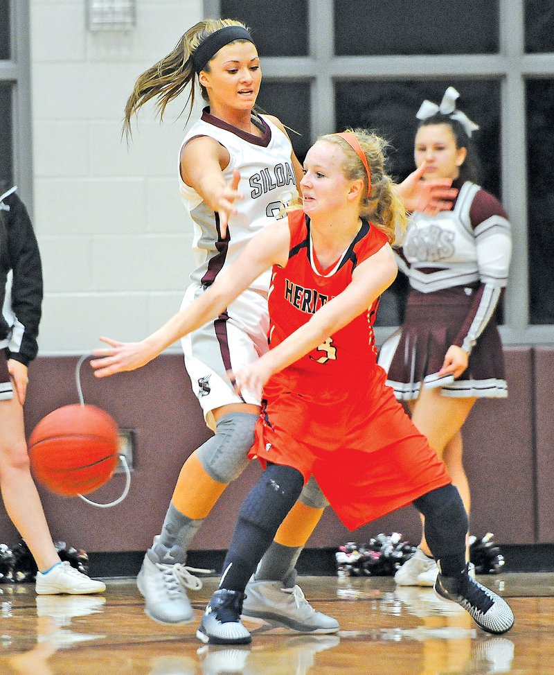 Staff Photo J.T. Wampler Emily Seiler of Rogers Heritage passes Friday while Siloam Springs&#8217; Mayse Pippin defends.
