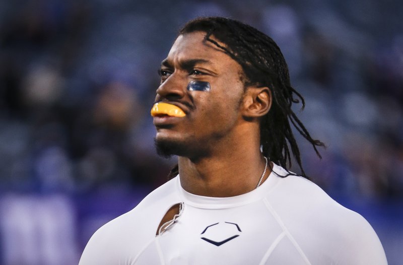 Washington Redskins quarterback Robert Griffin III walks off the field after the New York Giants won 24-13 in an NFL football game, Sunday, Dec. 14, 2014, in East Rutherford, N.J.