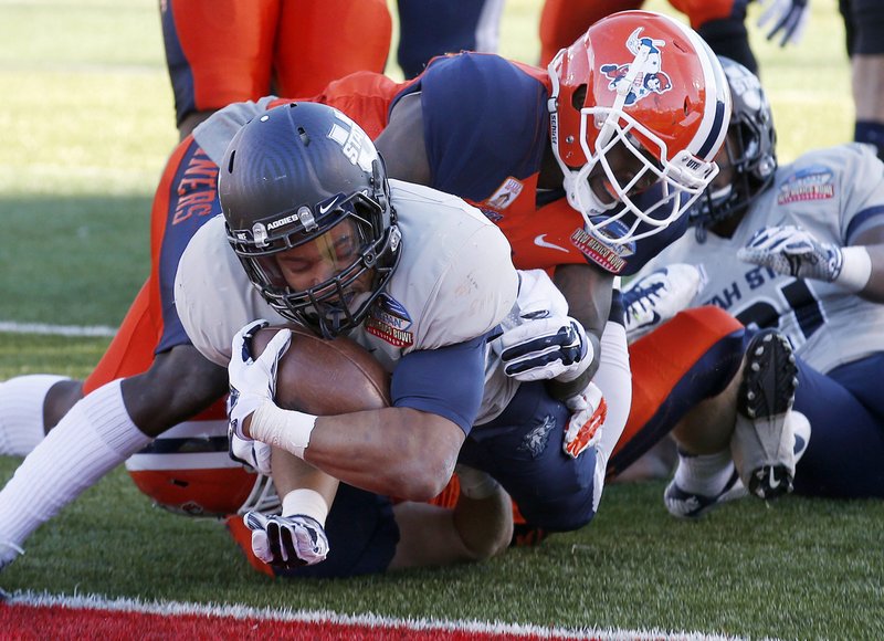 The Associated Press TOUCHDOWN MAKER: Utah State's Joe Hill, left, dives for a second-half touchdown as the Aggies defeat UTEP 21-6 in the New Mexico Bowl Saturday. Utah State, a bowl winner for the third-straight year, finished 10-4 and UTEP 7-6.