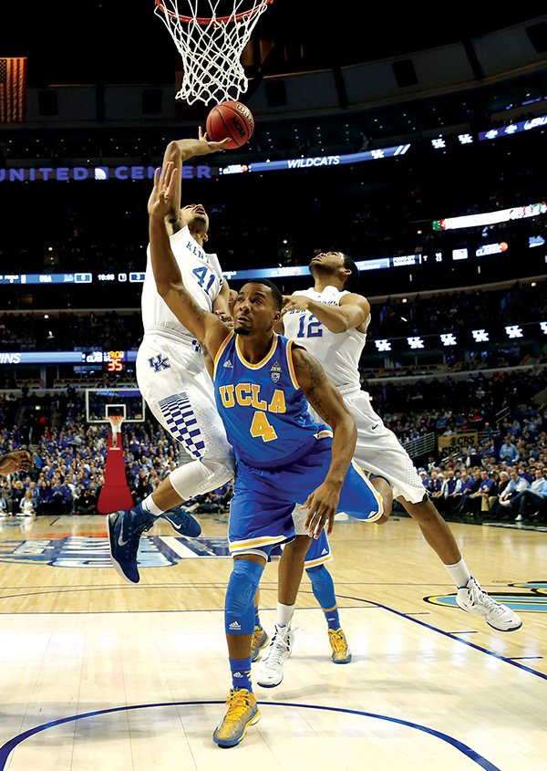 The Associated Press UP AND OVER: Kentucky forward Trey Lyles (41) shoots over UCLA guard Norman Powell (4) as Karl-Anthony Towns (12) watches for a rebound as the top-ranked Wildcats build a 41-7 halftime lead Saturday in Chicago. In a matchup of storied college-basketball programs, Kentucky rolled to an 83-42 victory for a 12-0 record.