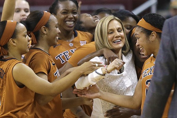 Texas coach Karen Aston, second from right, celebrates with her team after defeating Texas A&M in an NCAA college basketball game in North Little Rock, Ark., Sunday, Dec. 21, 2014. Texas defeated Texas A&M 67-65. (AP Photo/Danny Johnston)