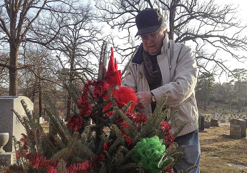 Arkansas Democrat-Gazette/Nikki Wentling - 12/21/2014 - Bob Gee, 81, decorates a tree at his brother's grave site in Roselawn Memorial Park December 21, 2014. Gee's brother died in 1928 at age 2 and has honored his memory with a Christmas every years since his death. 