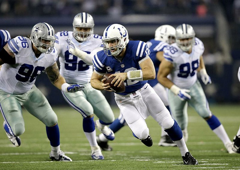 Indianapolis Colts quarterback Andrew Luck (12) scrambles out of the pocket under pressure from Dallas Cowboys' Nick Hayden (96), Jeremy Mincey (92) and Tyrone Crawford (98) during the first half of an NFL football game, Sunday, Dec. 21, 2014, in Arlington, Texas. (AP Photo/Tim Sharp)