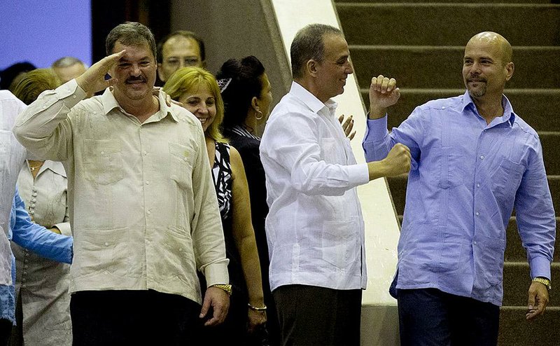 Ramon Labanino (from left), Antonio Guerrero and Gerardo Hernandez, members of the “Cuban Five” spy ring freed from U.S. imprisonment last week, are welcomed to Cuba’s parliament Saturday. At the session, President Raul Castro vowed to uphold his country’s communist system.