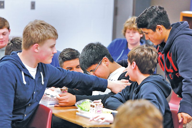 STAFF PHOTO DAVID GOTTSCHALK Melvin Rivera, center, an eighth-grader, receives support Thursday from students participating in the REAL Man program at Oakdale Middle School in Rogers. The character development program teaches students to respect all people, especially women, always do the right thing and live a life that matters.