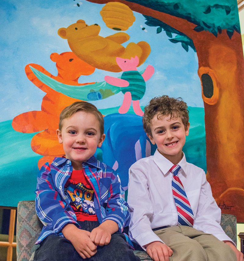 With some help from their parents, Grayson White, 7, and Langston White, 4, recently donated the Winnie the Pooh painting behind them to the Searcy Children’s Home. Jason White painted the scene before Grayson was born so that he and his wife, Stephanie, could hang it in their son’s nursery.