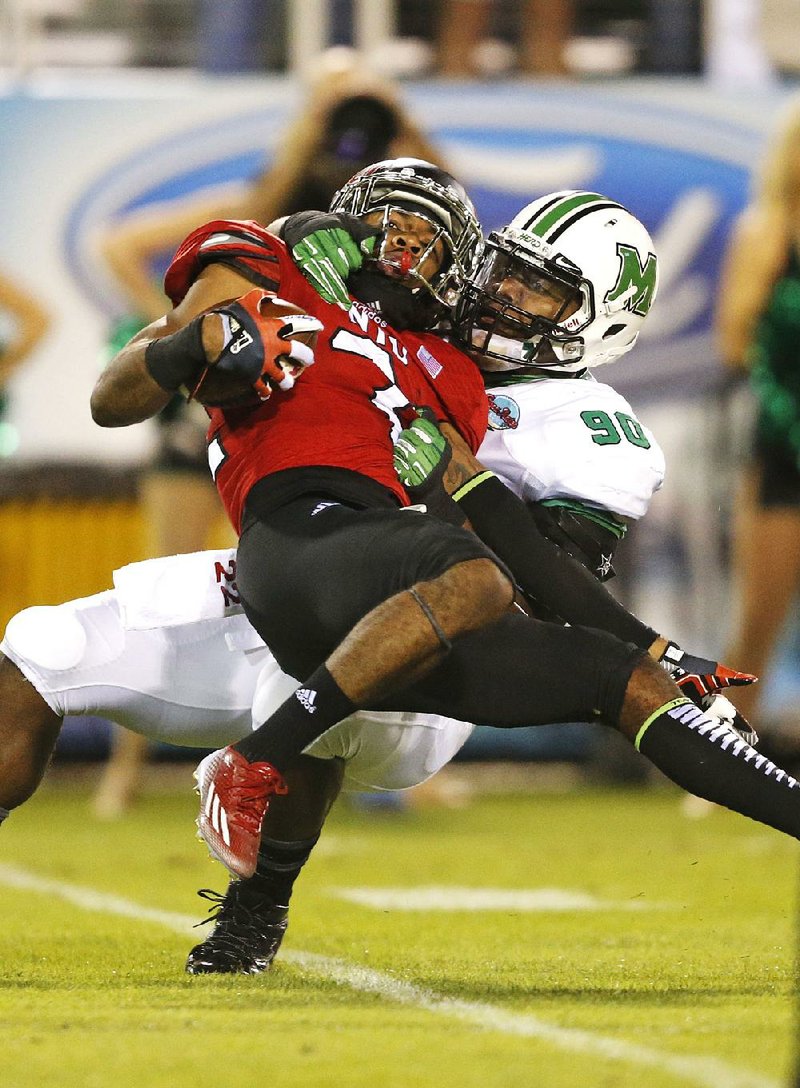 Boca Raton Bowl Marshall’s Arnold Blackmon (90) tackles Aregeros Turner of Northern Illinois during the first half of the Thundering Herd’s 52-23 victory in the Boca Raton Bowl. 