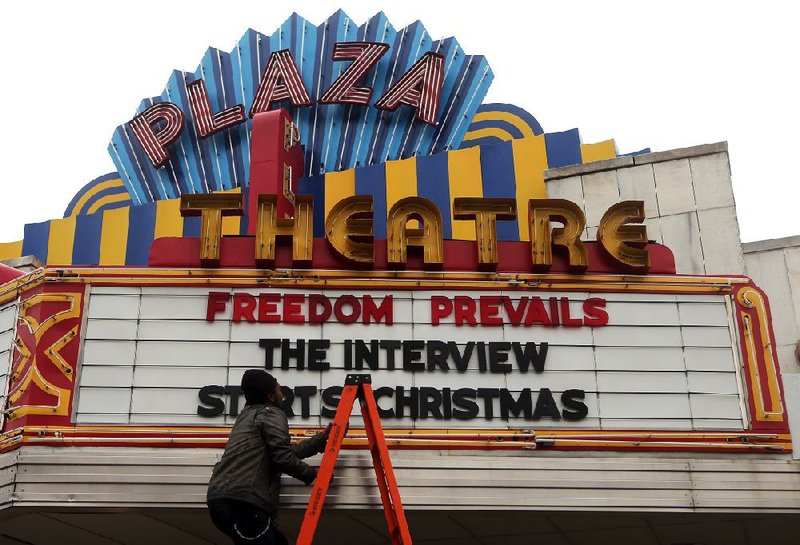Brandon Delaney, general manager of the Plaza Theatre in Atlanta, changes his marquee Tuesday to announce the showing of The Interview. 