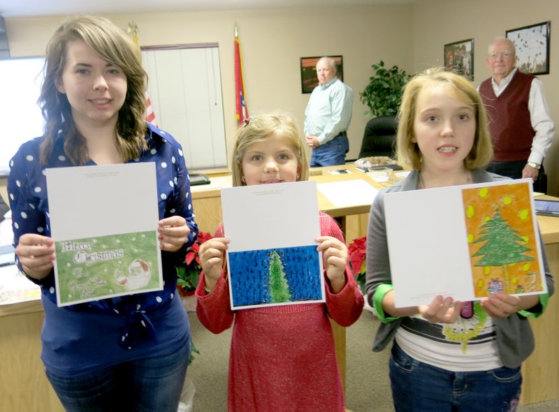 Photo by Susan Holland Winners of the Christmas card contest at Gravette schools attended the December 15 school board meeting and were introduced. The art teachers ask their students from each school to design cards and then pick the top picture from each grade. The administration office picks the top four winners, one from each school, and those students have their cards printed up and sent out to represent the Gravette School District. Each winner also receives a packet of the cards for her own use. Pictured here with their cards are Christina Bramel (left), 11th grade, winner from Gravette High School; Brooklyn Carte, second grade, from Glenn Duffy Elementary; and Hailey Baldwin, fifth grade, Gravette Upper Elementary. Ashlyn Newton, seventh-grade winner, from Gravette Middle School, was not present.