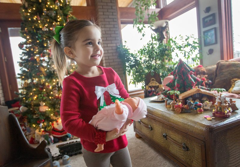 STAFF PHOTO JASON IVESTER Kinley Rollins, 2, plays with a doll in the living room of her grandparents&#8217; Springdale home. Kinley is the daughter of Paige and Joe Rollins. She is the granddaughter of Dee Gee and Bob Farrell and Teta and Jim Rollins.