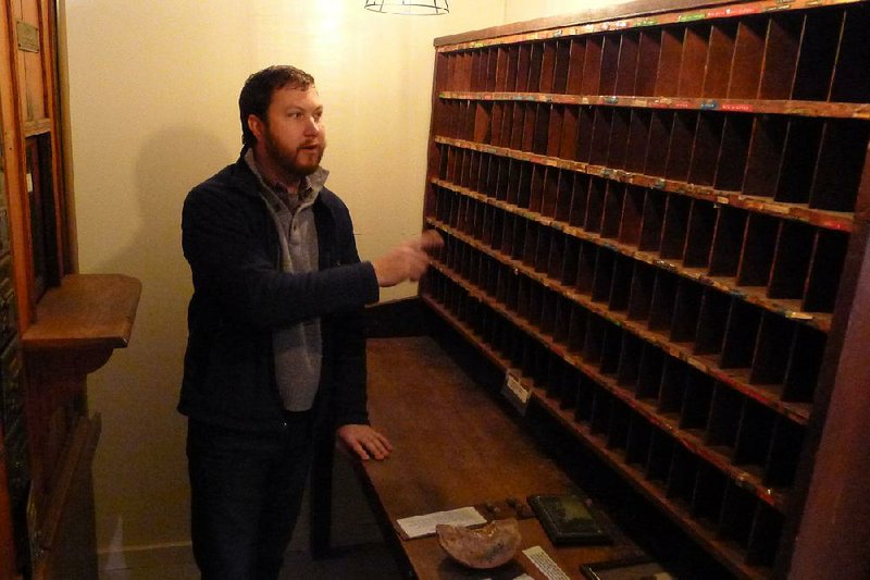 Bobby Braly, executive director of Historic Cane Hill Inc., talks about the wooden mail slots from the town’s historic post office. The mailboxes are part of a display in the Historic Cane Hill Museum’s new location. 