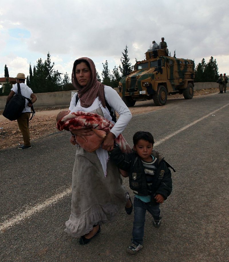 Syrian refugees arrive at the Turkey-Syria border near Suruc, Turkey, Monday, Sept. 29, 2014. 