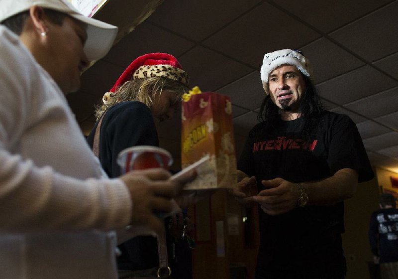 Riverdale 10 theater owner Matt Smith (right) takes tickets from Stephanie Carlo (left) and Tamara Fitzpatrick before the Thursday afternoon showing of The Interview. Riverdale and Smith’s other three theaters are the only ones to show the movie in the state.