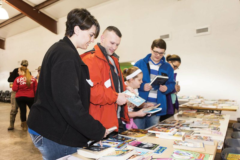 Tabitha and Matt Morris of Vilonia pick out books Monday during a toy giveaway at Vilonia Church of the Nazarene. They were with three of their six children, Zoey Hyten, 8; Colton Hyten, 15; and Jenna Hyten, 11. The couple’s home was damaged in the April 27 tornado in Faulkner County, and they have qualified for a Habitat for Humanity of Faulkner County home. It will have a 30-year, zero-interest mortgage.