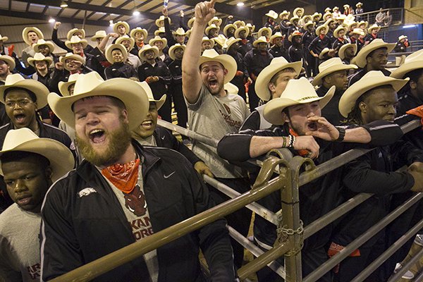 Razorback players cheer on team mates while participating in several rodeo style events against the University of Texas football team in the Rodeo Bowl Firday night in Houston in preparation for Monday night's Texas Bowl.