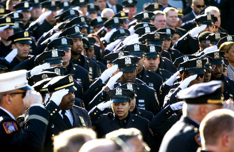 Thousands of police officers and others salute during the National Anthem as the funeral of New York City police officer Rafael Ramos begins at Christ Tabernacle Church in the Glendale section of Queens, where he was a member, Saturday, Dec. 27, 2014, in New York. Ramos and his partner, officer Wenjian Liu, were killed Dec. 20 as they sat in their patrol car on a Brooklyn street. The shooter, Ismaaiyl Brinsley, later killed himself.  (AP Photo/Craig Ruttle)