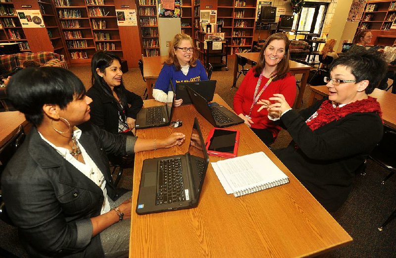 NWA Media/Michael Woods --12/18/2014-- w @NWAMICHAELW...Julie Cobb, a technology integration specialist at Ramsey Middle School in Fort Smith, (right) meets with Ramsey Middle School teachers (left to right) Marcia Hood, Maria Galvan, Cindy Dean and Mary Sutton Thursday morning in the school library to talk about planning for the next semester.  