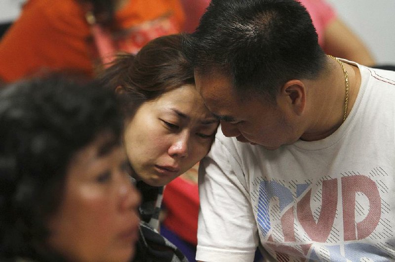 A relative of the passengers of AirAsia flight QZ8501 weeps as she waits for the latest news on the missing jetliner at a crisis center set up by local authority at Juanda International Airport in Surabaya, East Java, Indonesia, Sunday, Dec. 28, 2014.  A massive sea search was underway for an AirAsia plane that disappeared Sunday while flying from Indonesia to Singapore through airspace possibly thick with dense storm clouds, strong winds and lightning, officials said. (AP Photo/Trisnadi)